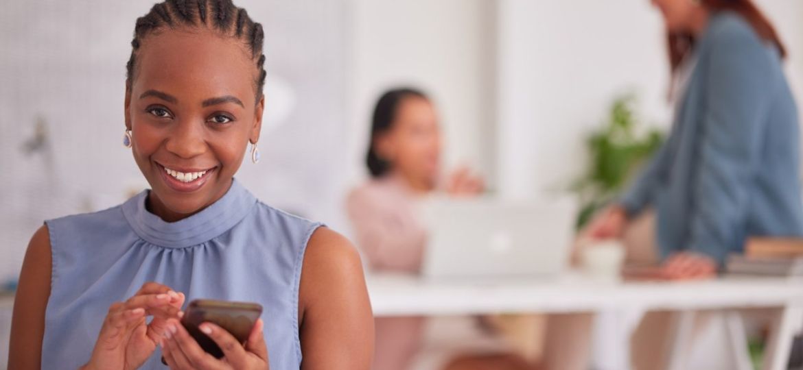 portrait-black-woman-and-smartphone-for-social-media-communication-and-with-smile-in-office-afri.jpg